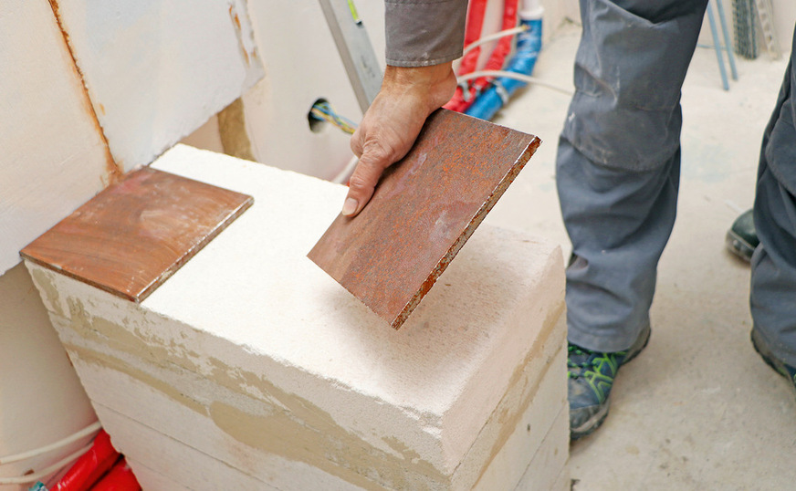 Zur Vermeidung von zu hoher Punktbelastung setzt der Ofenbauer 8 mm starke Stahlplatten ein, die paarweise auf den Gasbetonsockeln ausgelegt werden.